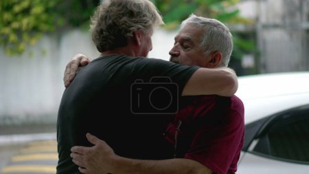 Foto de Abrazo amoroso auténtico entre dos amigos mayores que se despiden, abrazo conmovedor de las personas mayores, conexión y afecto familiar en la vida real - Imagen libre de derechos