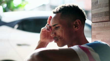 Photo for One preoccupied young black Brazilian man struggling with regret and bad memories, close-up face of an African American person with pensive worries - Royalty Free Image