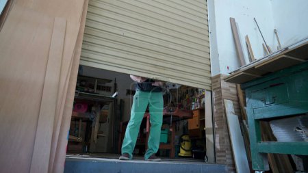Foto de Empresa local Propietario Cerrando tienda, Deslizamiento por la puerta del garaje de la tienda de carpintería - Imagen libre de derechos