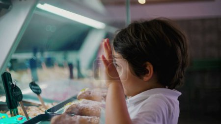 Photo for Kid at Ice-Cream Shop, Leaning on Counter and Examining Different Flavors, Capturing Indulgence of Childhood - Royalty Free Image