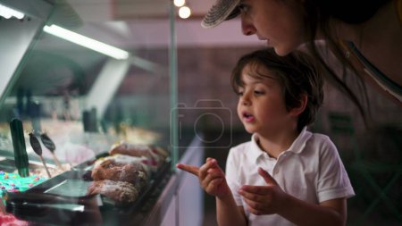 Photo for Small Boy Pointing at Ice-Cream Flavor, Choosing Dessert Behind Glass Counter - Royalty Free Image