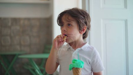 Photo for Child holding colorful ice-cream cone at parlor shop. Authentic kid eating sweet dessert food - Royalty Free Image