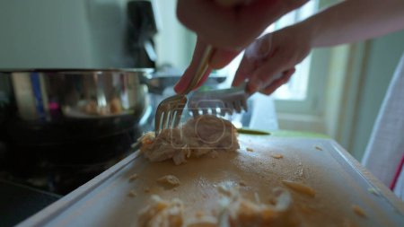 Foto de Primer plano / Separación manual de piezas de pollo con tenedor para la preparación de la comida - Imagen libre de derechos