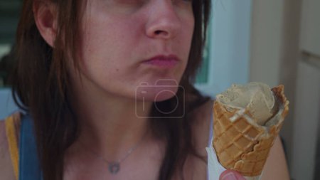 Photo for Close-up of woman mouth eating ice cream cone at italian parlor. Person enjoying Gelato during summer day, sugar gourmet dessert treat - Royalty Free Image