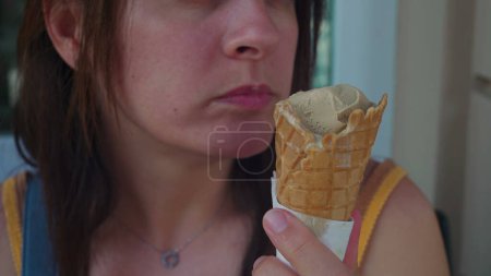 Photo for Close-up of woman mouth eating ice cream cone at italian parlor. Person enjoying Gelato during summer day, sugar gourmet dessert treat - Royalty Free Image