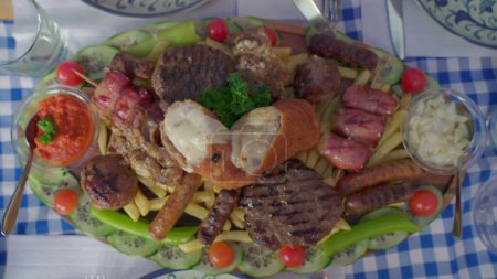 Téléchargez les photos : Assortiment de plats grecs abondants, saucisses de viande, frites, bacon, sauces, et arrangement de frites vu d'en haut. Variété de cuisine malsaine - en image libre de droit