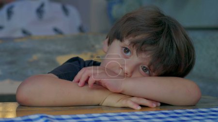 Photo for One pensive bored small boy displaying thoughtful expression daydreaming. Kid's boredom, lost in thought - Royalty Free Image