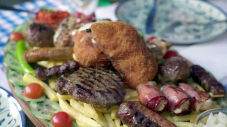 Téléchargez les photos : Dégustation sur les saveurs grecques de viandes, légumes et côtés assortis disposés pour le dîner - en image libre de droit