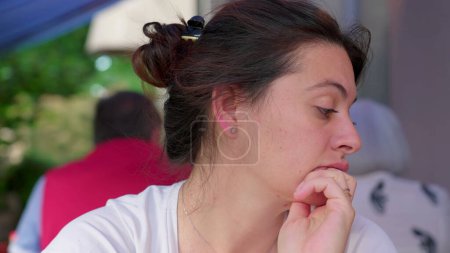 Photo for Pensive 30s woman close-up face gazing in the distance thinking while waiting for food at restaurant. contemplative expression of person, authentic and real life - Royalty Free Image