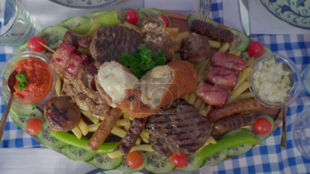 Téléchargez les photos : Assortiment de plats grecs abondants, saucisses de viande, frites, bacon, sauces, et arrangement de frites vu d'en haut. Variété de cuisine malsaine - en image libre de droit