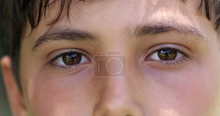 Téléchargez les photos : Boy closing and opening eyes close-up. Meditative Macro closeup of child eye looking to camera - en image libre de droit