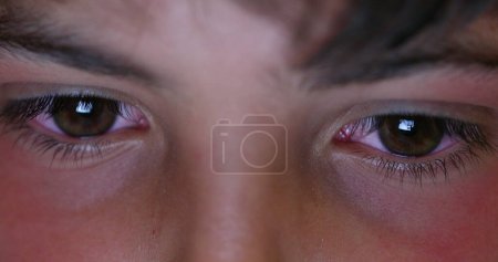 Photo for Boy macro eyes staring at screen device at night. Child browsing internet eye close-up - Royalty Free Image