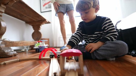 Téléchargez les photos : Enfant jouant avec des voitures-jouets sur plancher de bois franc - en image libre de droit