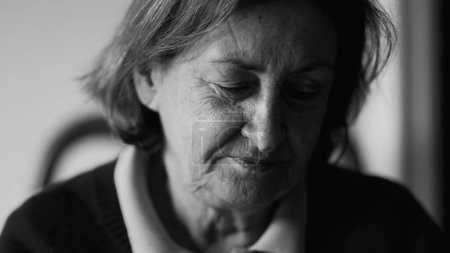 Foto de Cara de cerca de mujer mayor pensativa en monocromo, señora anciana pensativa en los años 70 pensando en blanco y negro - Imagen libre de derechos