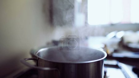 Foto de Aumento de vapor de la cacerola de metal en la estufa de la cocina, proceso de cocina en marcha - Imagen libre de derechos
