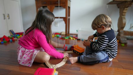 Photo for Child playing at home on floor, little boy and girl engrossed in play, siblings brother and sister sharing toys - Royalty Free Image