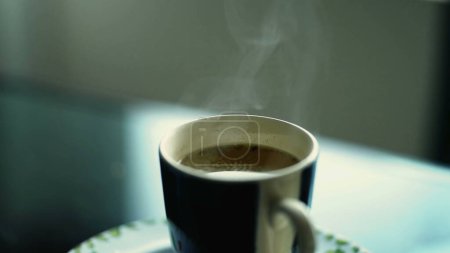 Photo for Hot warm drink with steam coming out, close-up of tea cup on table - Royalty Free Image