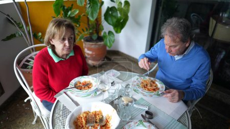 Téléchargez les photos : Couple de personnes âgées profitant du déjeuner sur l'appartement Balcon, mari et femme à la retraite partageant des moments de repas sur la terrasse ensemble, mode de vie domestique scène de vieillesse - en image libre de droit