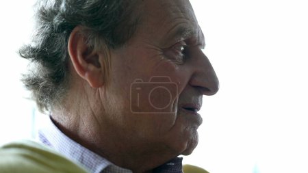 Photo for Anxious senior man close-up face biting lips feeling distressed while contemplating decision, introspective elderly caucasian person in 70s, genuine and authentic emotion - Royalty Free Image