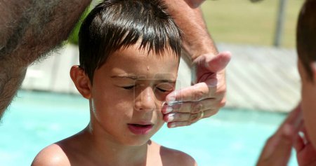 Photo for Father applying sunblock lotion to child face. Parent applies sunscreen to boy skin - Royalty Free Image