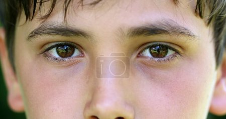 Foto de Primer plano de los ojos de un chico joven mirando a la cámara sonriendo. Macro ojos primer plano del niño - Imagen libre de derechos