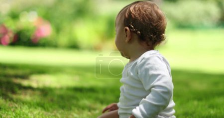 Téléchargez les photos : Bébé bébé mignon tout-petit dehors dans la pelouse de la maison - en image libre de droit
