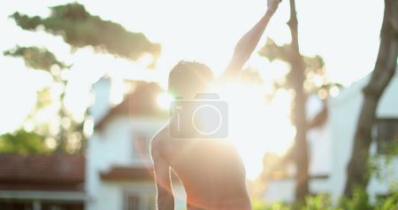 Photo for Confident child celebrating success by raising fists in the air. Boy raises arms in the sky in celebration - Royalty Free Image