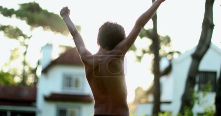 Foto de Excited child celebrating success with arms in the air - Imagen libre de derechos