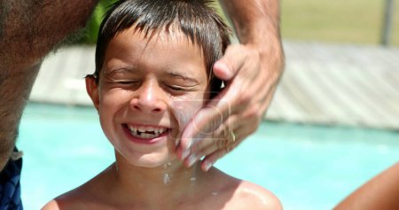 Photo for Father applying sunblock lotion to child face. Parent applies sunscreen to boy skin - Royalty Free Image