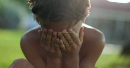 Téléchargez les photos : Child covering face with shame. Boy hinding face with hands - en image libre de droit
