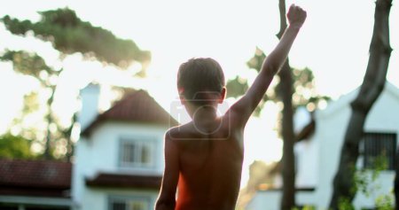 Photo for Excited child celebrating success with arms in the air - Royalty Free Image