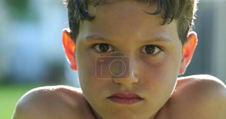 Photo for Serious child boy becoming angry. Kid portrait face getting upset, looking to camera frowning - Royalty Free Image