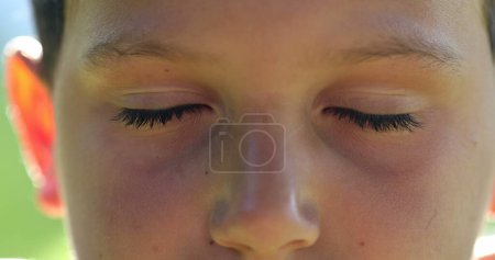 Photo for Kid face close-up closing eyes in meditation. Child boy opening eyes smiling to camera, macro closeup - Royalty Free Image