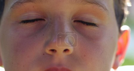 Téléchargez les photos : Jeune garçon prenant une profonde respiration dans la méditation. Enfant ouvrant l'œil, gros plan macro oeil d'enfant respirant - en image libre de droit