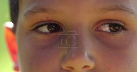 Téléchargez les photos : Pensive child eyes looking to camera close-up. Young boy macro eye staring and looking dreamlike - en image libre de droit