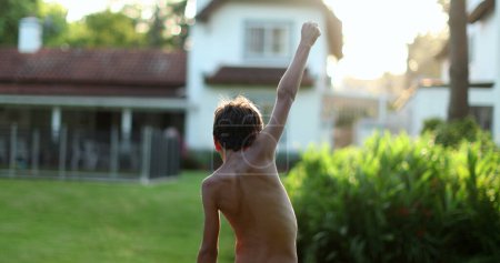 Foto de Joven niño levantando puño en el cielo en pie de la victoria - Imagen libre de derechos