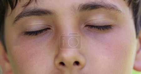Téléchargez les photos : Jeune garçon fermant les yeux en contemplation et en méditation. Pensif réfléchi enfant ouverture oeil - en image libre de droit