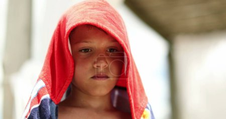 Téléchargez les photos : Pensive child boy wrapped with towel after swimming at the pool. Thoughtful kid drying body - en image libre de droit