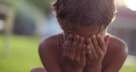 Photo for Young boy covering face feeling sad and ashamed - Royalty Free Image