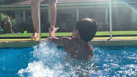 Photo for Brothers quarrel at the swimming pool, two siblings conflict and playing - Royalty Free Image