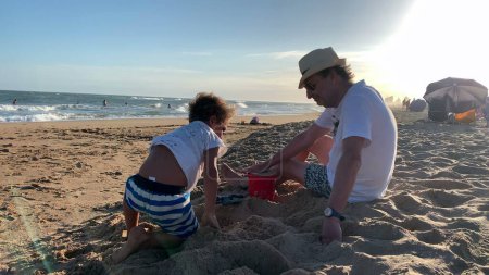 Foto de Abuelo y nieto en la playa jugando - Imagen libre de derechos