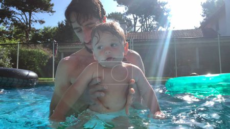 Photo for Father holding baby infant son at the pool outdoors - Royalty Free Image