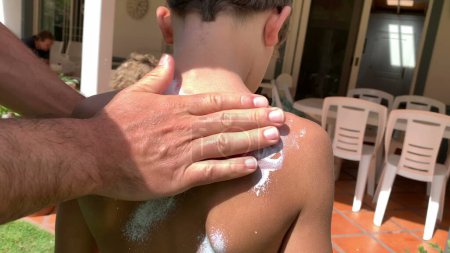 Photo for Father applying sunscreen lotion to child boy back. Parent rubbing sunblock to kid - Royalty Free Image