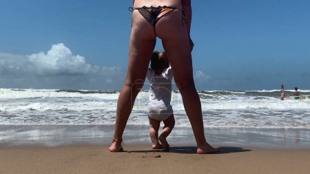 Foto de Lindo bebé en la playa para los abetos tiempo. Madre e hijo pequeños dedos de los pies y pies sintiendo sensación de agua del océano - Imagen libre de derechos