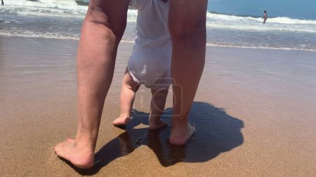 Photo for Infant baby first steps at beach barefoot - Royalty Free Image
