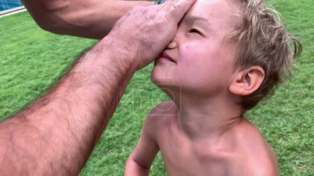 Téléchargez les photos : Père étalant de la crème solaire sur le visage d'un enfant en bas âge. Parent appliquant protection solaire prévention - en image libre de droit
