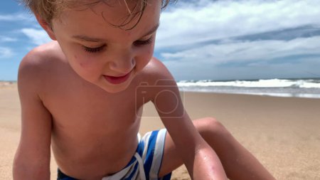 Téléchargez les photos : Enfants à la plage jouant avec la construction de sable château de sable - en image libre de droit