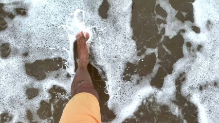 Téléchargez les photos : Point de vue de l'homme sur l'eau de la plage. POV marche au bord de la mer - en image libre de droit
