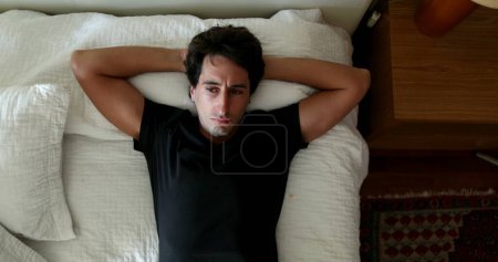 Photo for Man lying down in bed thinking about solution to problem. Person taking a decision and getting out of bed - Royalty Free Image