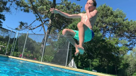 Foto de Niño corriendo y saltando en el agua de la piscina - Imagen libre de derechos